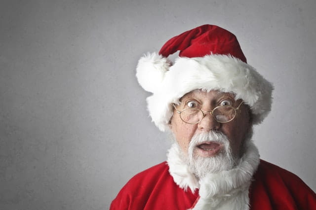 Père Noël étonné de voir des cadeaux insolites.
