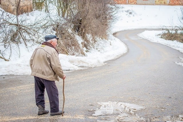 Personne âgée marchant avec une canne.