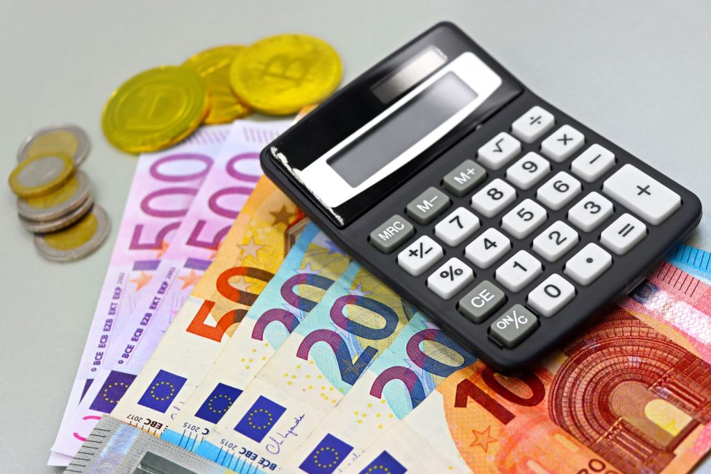 Billets et pièces en euros posés près d'une calculatrice