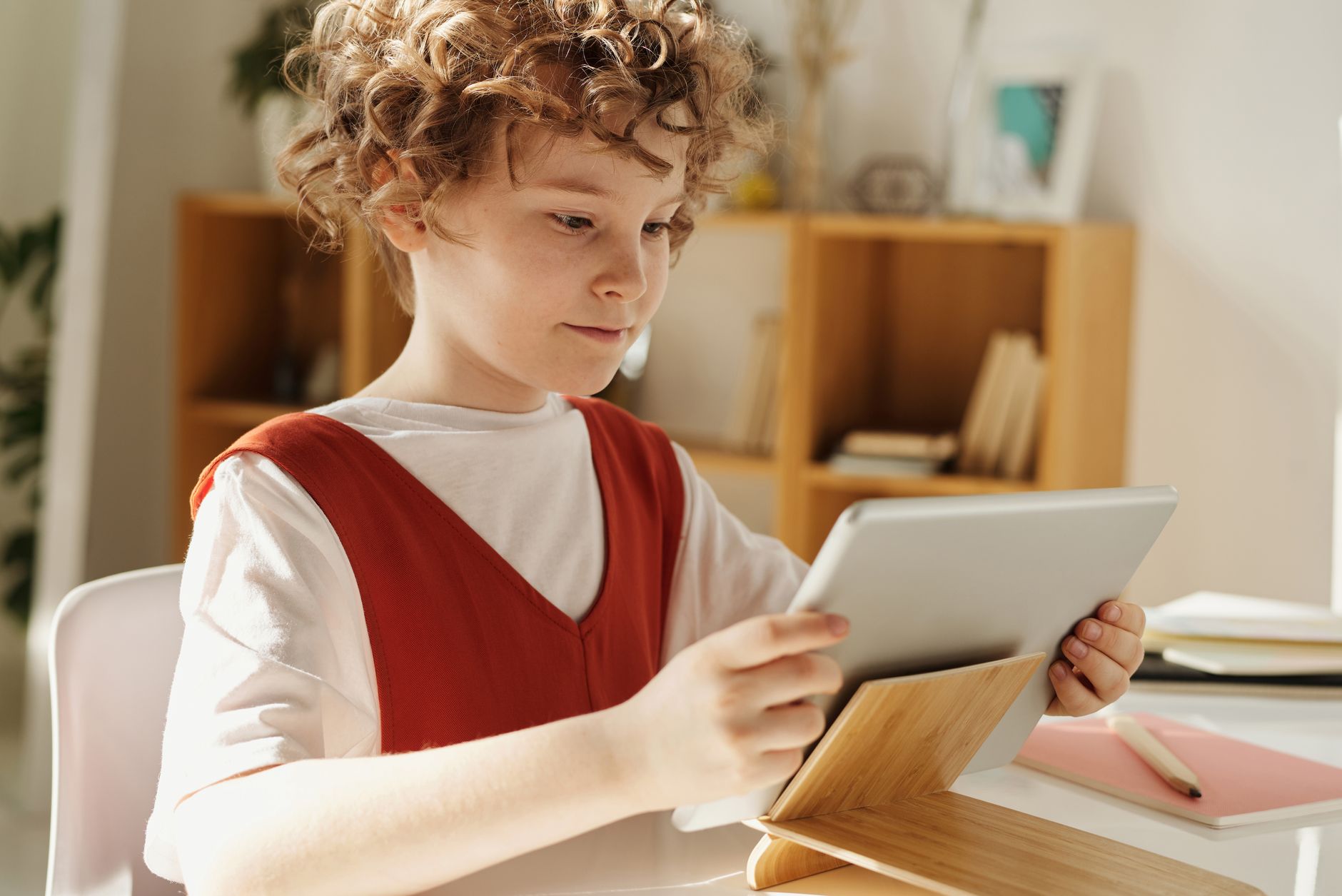 Un enfant utilise une tablette numérique dans un cadre lumineux, illustration de l'éducation et du numérique