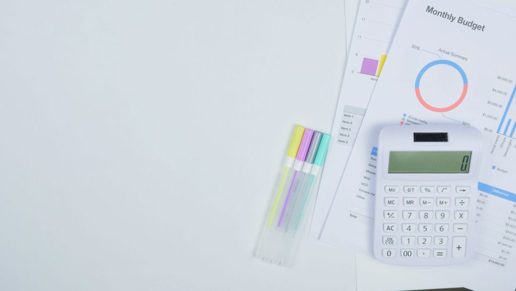 Documents de préparation budgétaire et calculatrice posés sur un bureau